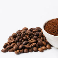 Coffee beans and ground coffee in a bowl on a white background